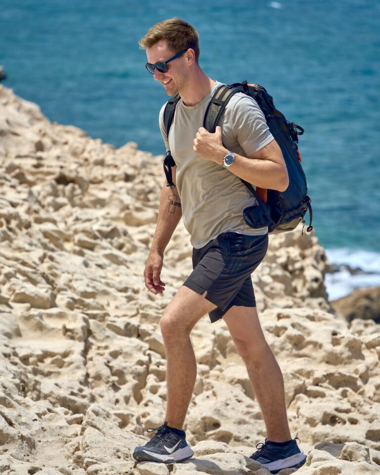 Max Haase hikes along the coast wearing a NOMOS watch