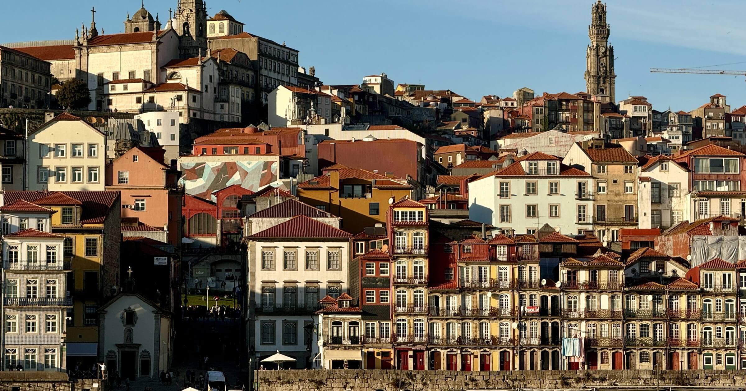 Bunte Häuser der Ribeira in Porto, dahinter der Torre dos Clérigos