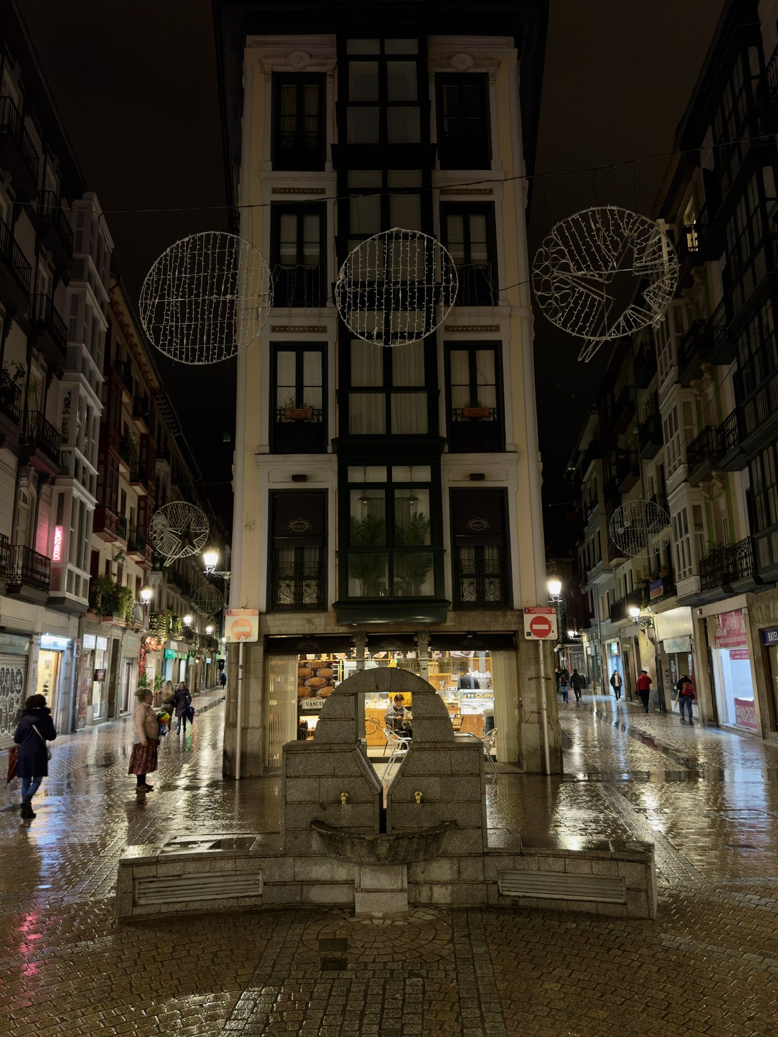 Gasse in der Altstadt von Bilbao mit Brunnen am Abend