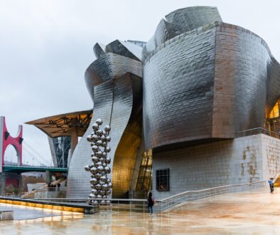 Guggenheim-Museum Bilbao mit Edelstahlkugel-Skulptur und roter La-Salve-Brücke am Fluss Nervión